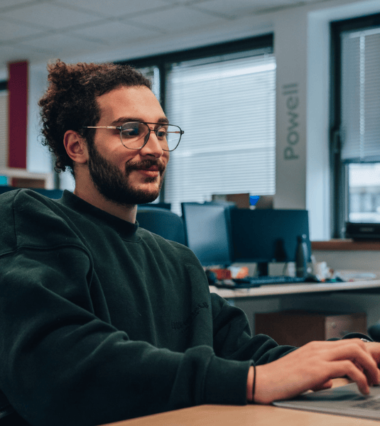 Powell employees in office working on computer